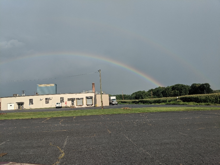 This picture shows a double rainbow over a field.