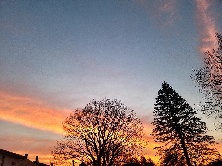 This picture shows streaks of orange and pink clouds during sunrise..
