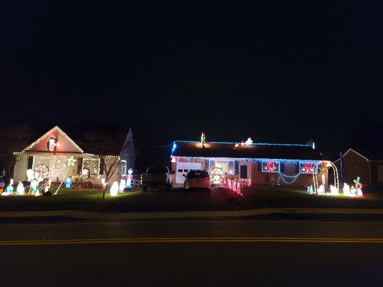 This picture shows two houses with numerous Christmas lights.