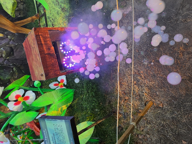 This photo shows an interactive thing at the Chinese lantern festival that blew out bubbles that were lit up and you could pop.
