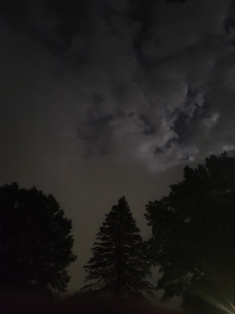 This picture shows a departing thunderstorm that is lit up by the full moon