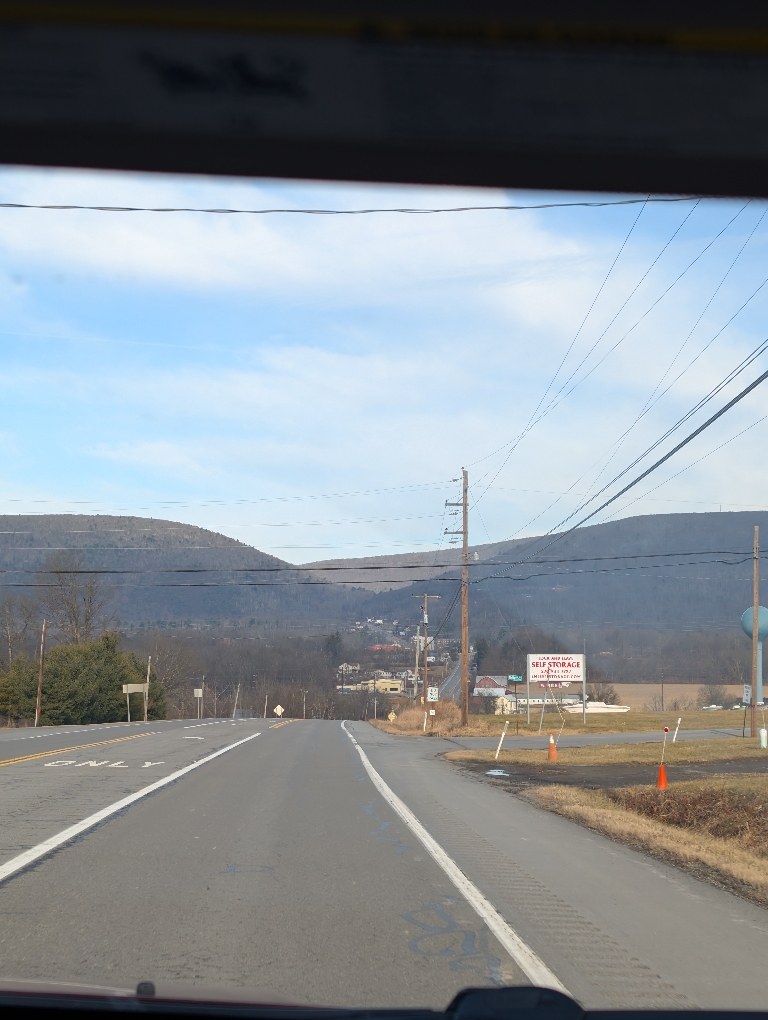This picture shows mountains straight ahead on a road.