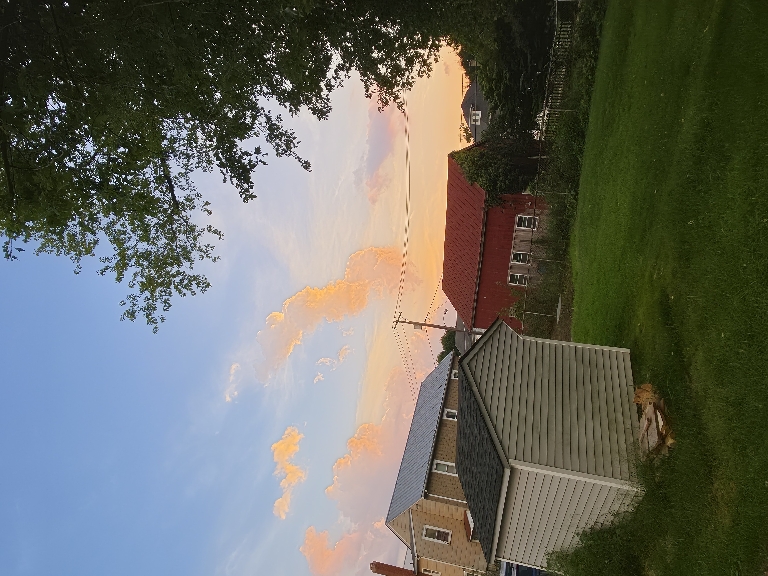 This picture shows low a few very orange clouds to the west againsta mostly clear blue skie.