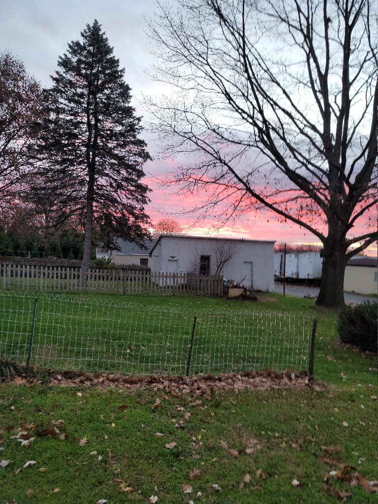This is a picture of the early morning sky at sunrise. The horizon is still a fairly deep red with pinks above it.