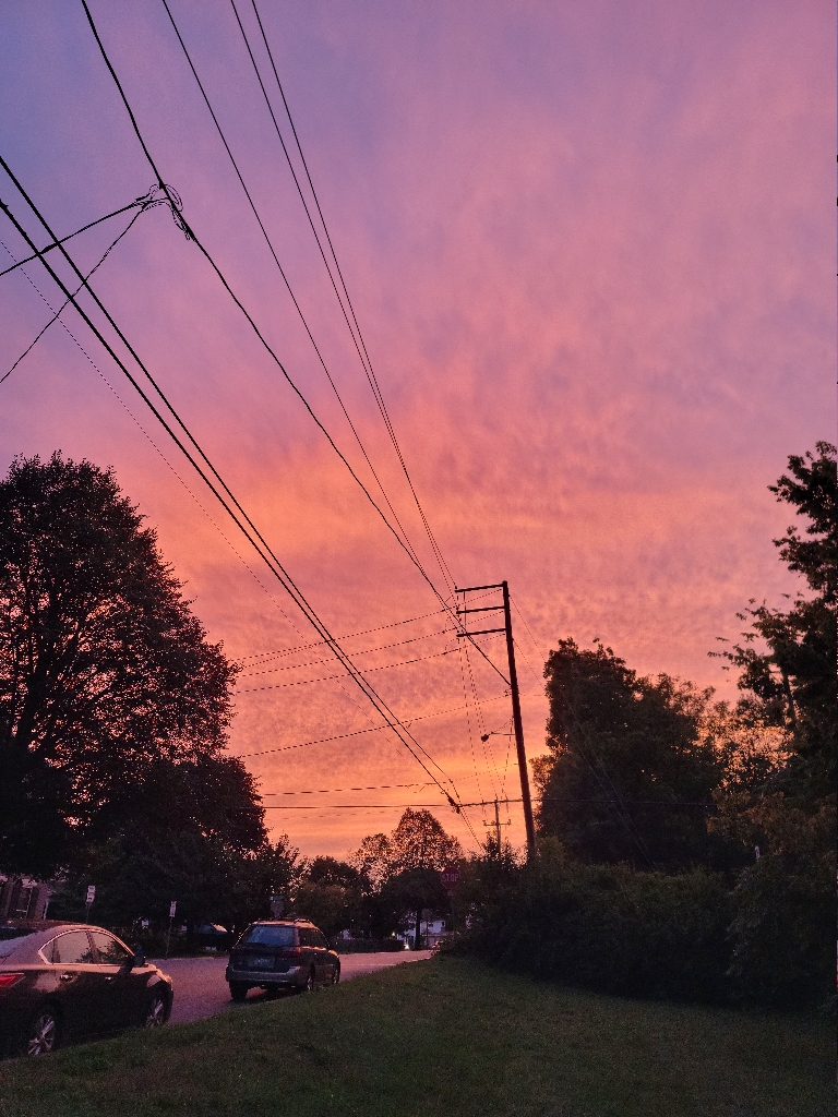 This picture shows a very colorful sky from the sunset as the clouds out ahead of a tropical system are moving in overhead. The clouds are a range of colors from orange to pink to purple and everything in betweeen.