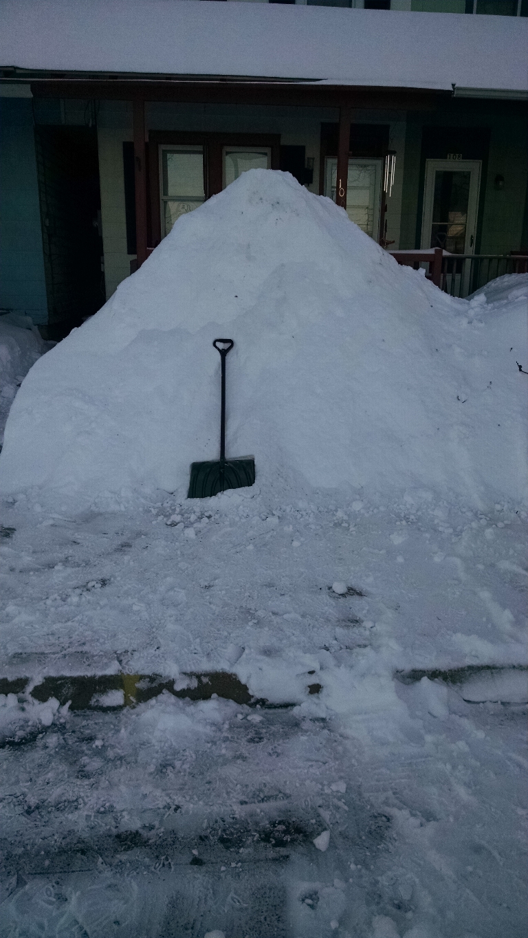 This photo is of large snow pile in front of a house since there was nowhere else to put ita