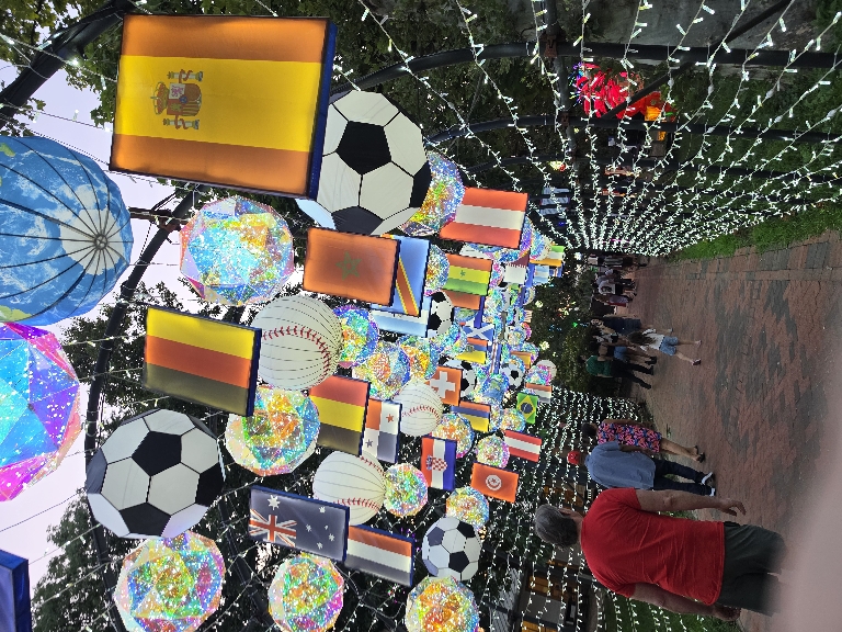 This photo shows an tunnel themed with baseballs and soccer balls and other stuff related to the World Cup And MLB All Star Game.