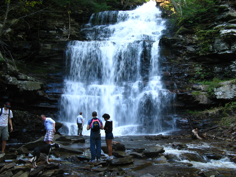 This photograph depticts a tall and multi tiered waterfall.