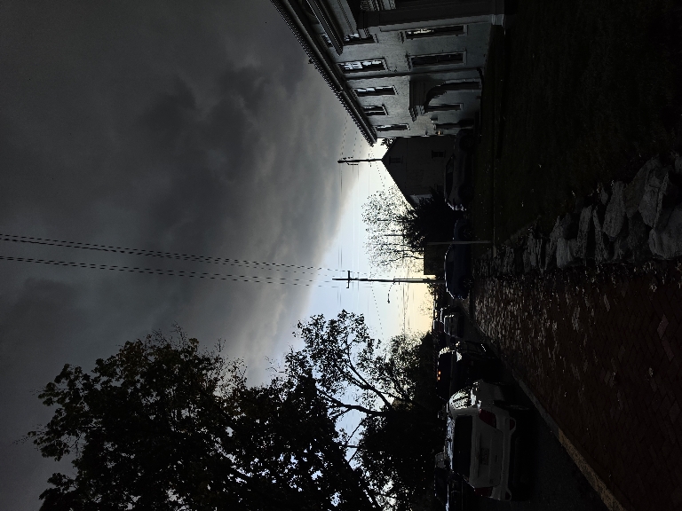 This picture shows clear blue skies from underneath a very dark storm cloud
