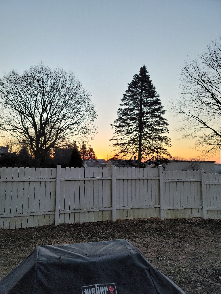 This picture is of a sunrise. The clouds near the horizon are an orange like color.