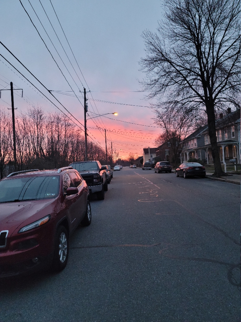 This is a picture the a very colorful sunrise. The sky is a deep pinkish orange towards the horizon with a purple glow above that.